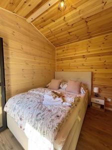 a bedroom with a bed in a wooden cabin at Le Petitou in Všeruby