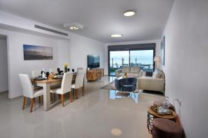a dining room and living room with a table and chairs at Levication Tiberias Luxury Private Pool Apartments in Tiberias