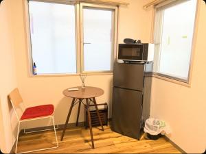 a small kitchen with a refrigerator and a table at Small stay in Tokyo in Tokyo