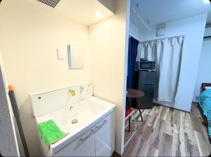 a bathroom with a white dresser with a green towel at Small stay in Tokyo in Tokyo