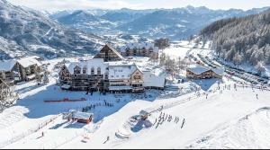 a group of people in the snow in front of a ski lodge at Chalet des Aigles Reallon in Réallon