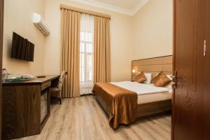 una habitación de hotel con una cama y un escritorio en Old Passage Hotel, en Baku 150 fotos más