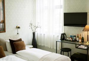 a bedroom with a bed and a desk and a window at Park Hotel & Vinbar in Frederikshavn