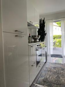 a white kitchen with a stove and a sink at Ferienwohnung Little Something in Tecklenburg