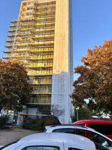 un edificio alto con macchine parcheggiate di fronte di Charming apartment with a view a Wolfsburg