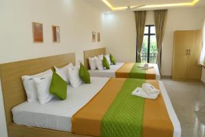 two beds in a room with green and white at Hotel Aeroview Near Chennai Airport in Chennai