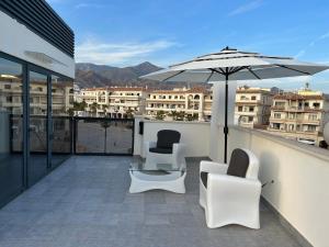 ネルハにあるSmile Luxury Apartmentsのパティオ(椅子2脚、パラソル付)