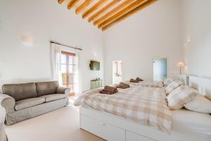 a white bedroom with a large bed and a couch at Finca Mar des Teix in Manacor +92 photos