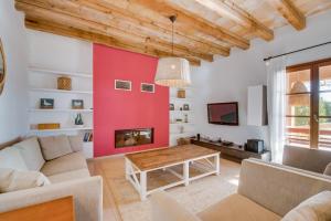 a living room with a red accent wall at Finca Mar des Teix in Manacor