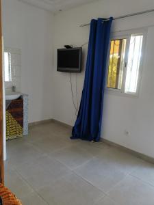 Una televisión o centro de entretenimiento en chambre avec piscine proche mer,5 mn de Cap Skirring ,proche Senegaulois 4 fotos más