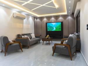 Una sala de estar con sofás y un televisor de pantalla plana. en Lyva chalet, en Al Rama