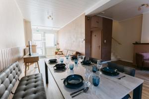 a dining room table with plates and glasses on it at vakantiewoning 't Rijhuys in Diksmuide