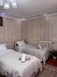 ビシュケクにあるCholpon Guest Houseのベッド2台とシャンデリアのある寝室