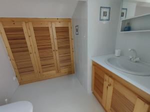 a bathroom with a sink and a wooden door at Chambre avec clim piscine proche centre ville d'Uzès in Saint-Siffret