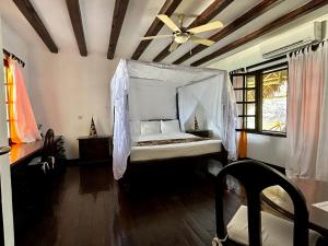 a bedroom with a bed with a ceiling fan at Blue Bay Village in Watamu +122 photos