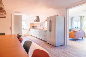 a white refrigerator in a kitchen with a table at Noorderzon in Buren