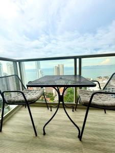 a table and two chairs on a balcony with a view at Riviera Wongamat in Pattaya North