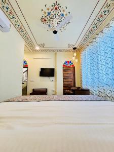 a bedroom with a large bed and a tv at Virasat Haveli - A Heritage Boutique Hotel in Sawāi Mādhopur +9 photos