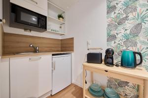 a small kitchen with a sink and a microwave at Les tuiles bourguignonnes in Fontaine-lès-Dijon