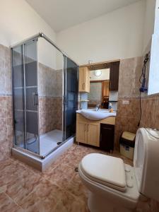 a bathroom with a shower and a toilet and a sink at Blissful Hostel in Shkodër