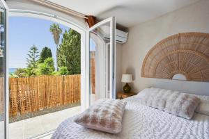 a bedroom with a bed and a view of the ocean at De l'élégance au bord de l'eau in La Ciotat