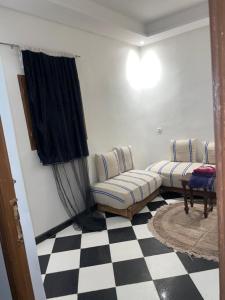 a living room with a couch and a checkered floor at Mini Studio in Marrakech +1 photo