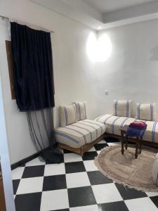 a living room with couches and a checkered floor at Mini Studio in Marrakech