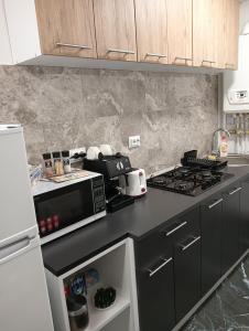a kitchen with a black counter top with a microwave at Apartament HD3 in Hunedoara +20 photos