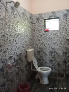 a bathroom with a toilet and a window at Swapno Chhobi in Shānti Niketan +21 photos