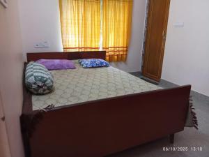 a bed with two pillows on it in a bedroom at Swapno Chhobi in Shānti Niketan
