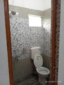 a bathroom with a toilet and a shower at Swapno Chhobi in Shānti Niketan
