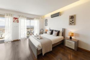 a bedroom with a large bed and a large window at Atlantic Panoramic Villa in Salir de Porto