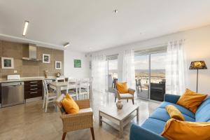 a living room with a blue couch and a kitchen at Atlantic Panoramic Villa in Salir de Porto
