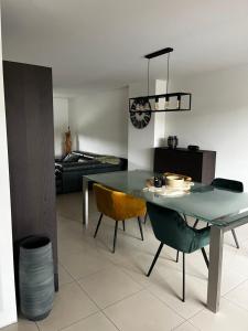 a dining room with a glass table and chairs at Duplex appartement 'De Wijers' met 3 slaapkamers in Genk