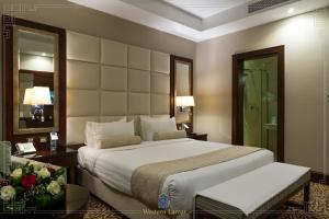 une chambre avec un grand lit et un miroir dans l'établissement شقق لمار الغرب الفاخرة, à Djeddah