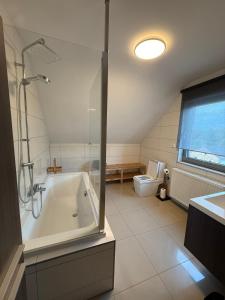 a bathroom with a shower and a tub and a toilet at Duplex appartement met 3 slaapkamers in Genk +5 photos