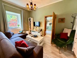a living room with a couch and a chair at Ausseerland Apartments - Relax, Ski, Hike and Bike, Garden, Parking, BBQ, Near Hallstatt, Loser, Tauplitz and Krippenstein, Free Wi-Fi and Netflix in Bad Aussee