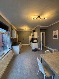 サンダーランドにあるAffordable Luxury 2 Stunning apartment Sunderland close to City centre hospital Crown Works Studio and Nissanの空のキッチン、リビングルーム(テーブル、椅子付)