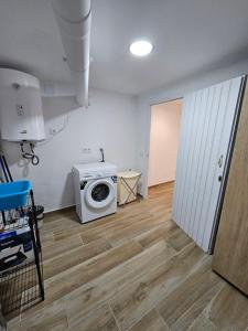 a laundry room with a washing machine and a door at Modern Duplex Studio with BBQ in Molnás +23 photos