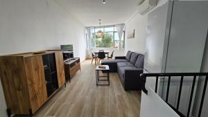 a living room with a couch and a table at Modern Duplex Studio with BBQ in Molnás