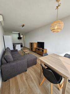 a living room with a couch and a table at Modern Duplex Studio with BBQ in Molnás