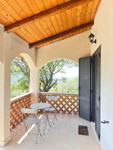 a patio with a table and chairs and a wooden ceiling at La Rosa di Tempalta in Roccadaspide