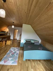 a bed in a room with a wooden ceiling at Pension Harmony in Liptovský Michal