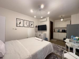 une chambre blanche avec un lit et une cuisine dans l'établissement 33A4. Rooftop Studio w Terrace Green Views, à Sheikh Zayed