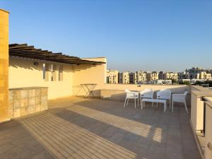 un patio avec des chaises et une table sur un toit dans l'établissement 33A4. Rooftop Studio w Terrace Green Views, à Sheikh Zayed