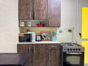 a kitchen with wooden cabinets and a stove and a microwave at 2 BR entire apartment - 1402 in Sheikh Zayed