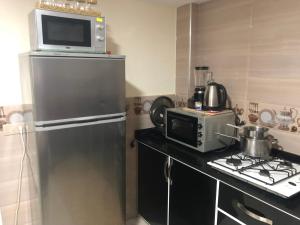 une cuisine avec un réfrigérateur et un micro-ondes dans l'établissement شقة للكراء اليومي, à Segangane