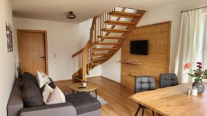 una sala de estar con una escalera de madera y una mesa en Apartments by Pension Ballwein, en Salzburgo