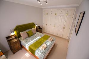 Un dormitorio con una cama con cabecero verde. en Bacon del Mar Apartment, en Costa del Silencio