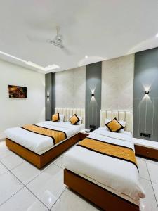 two beds in a room with two beds sidx sidx sidx sidx at Hotel Apple in Phardāpur